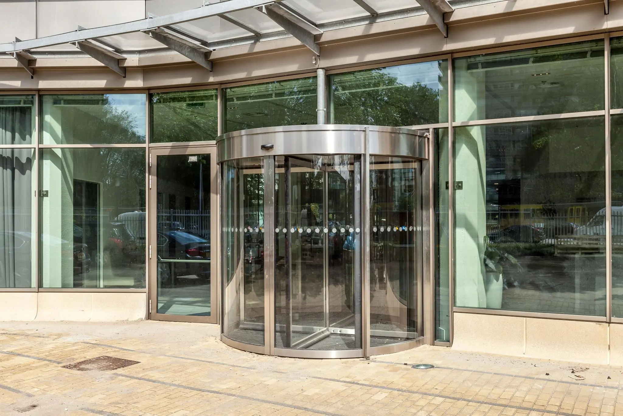 Glazen draaideur bij de ingang van een modern kantoorgebouw aan de Vliegend Hertlaan.